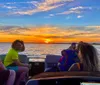 A group of people enjoys a vibrant sunset from the deck of a boat showcasing a relaxed and picturesque moment