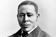 The image is a black and white portrait of Scott Joplin, an African American composer and pianist known as the 
