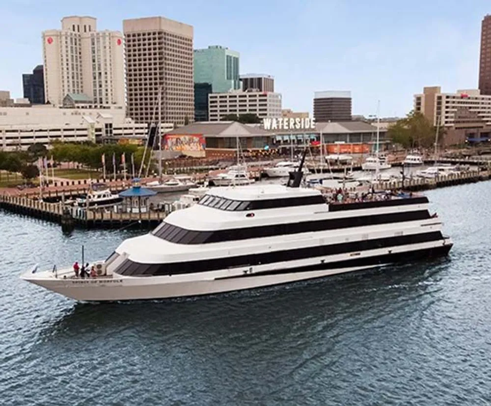 A large multi-deck boat with passengers is docked near a busy waterfront area with the Waterside sign in the background