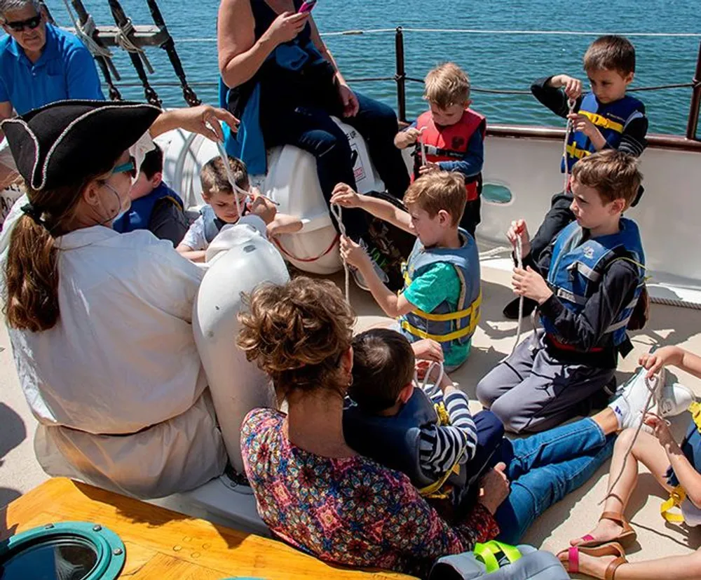 Children and adults are interactively engaged on a boat with a person in pirate attire guiding the activity
