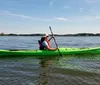 Two people are smiling while kayaking together on a sunny day