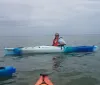 Two people are smiling while kayaking together on a sunny day
