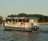 A ferry named Jamestown Discovery is cruising on the water with passengers on board during what appears to be late afternoon