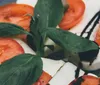 A chef is meticulously plating a dish with tweezers amid a smoky presentation on wooden surfaces suggestive of an upscale gourmet experience