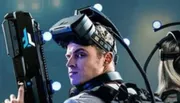 A person is wearing a sophisticated virtual reality (VR) headset with motion tracking markers, apparently engaged in an immersive experience.