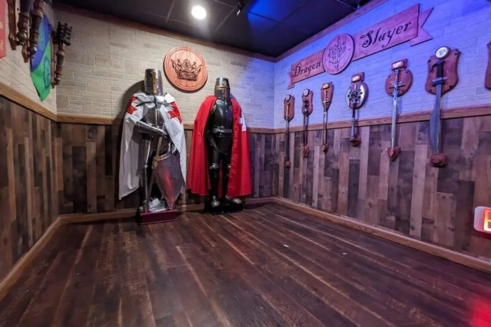 The image shows a themed room with two sets of medieval-style armor standsone in silver and the other in blacknext to a wall adorned with shields and maces creating a knightly ambiance