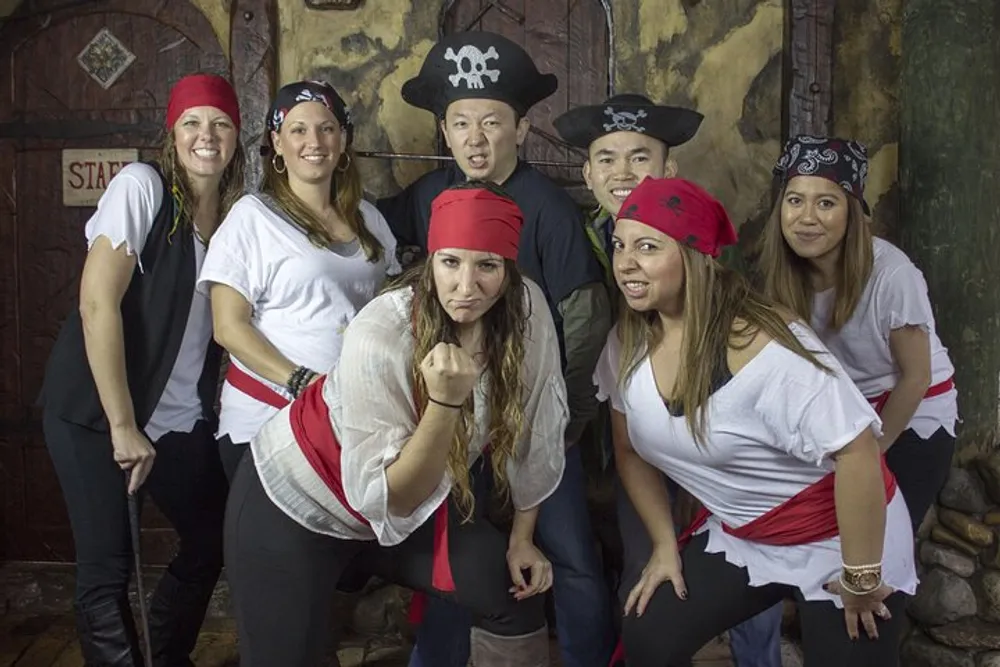 A group of people are posing enthusiastically in pirate-themed costumes
