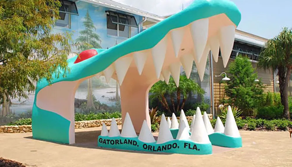 The image shows a large colorful entrance arch shaped like an alligators open mouth at Gatorland in Orlando Florida
