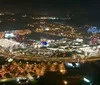The image features a nighttime aerial view of a lively amusement park with vibrant fireworks bursting over lit-up attractions and bodies of water