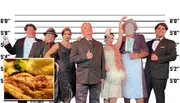 Seven people dressed in vintage formal attire stand in front of a height chart backdrop.