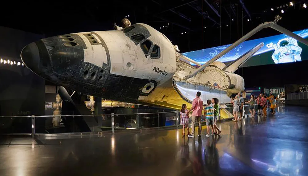 Visitors are observing the Space Shuttle Atlantis exhibit at the Kennedy Space Center Visitor Complex