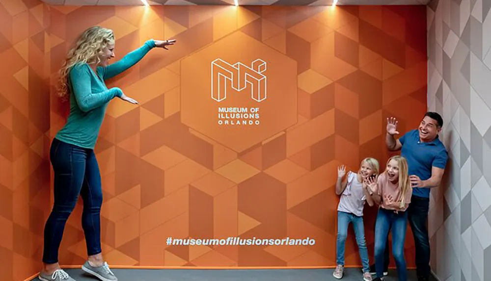 A woman appears to slide down an inclined surface while a family of three pretends to be squashed against a wall creating an optical illusion at the Museum of Illusions Orlando