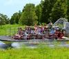 A group of tourists is enjoying a ride on an airboat in a lush wetland environment