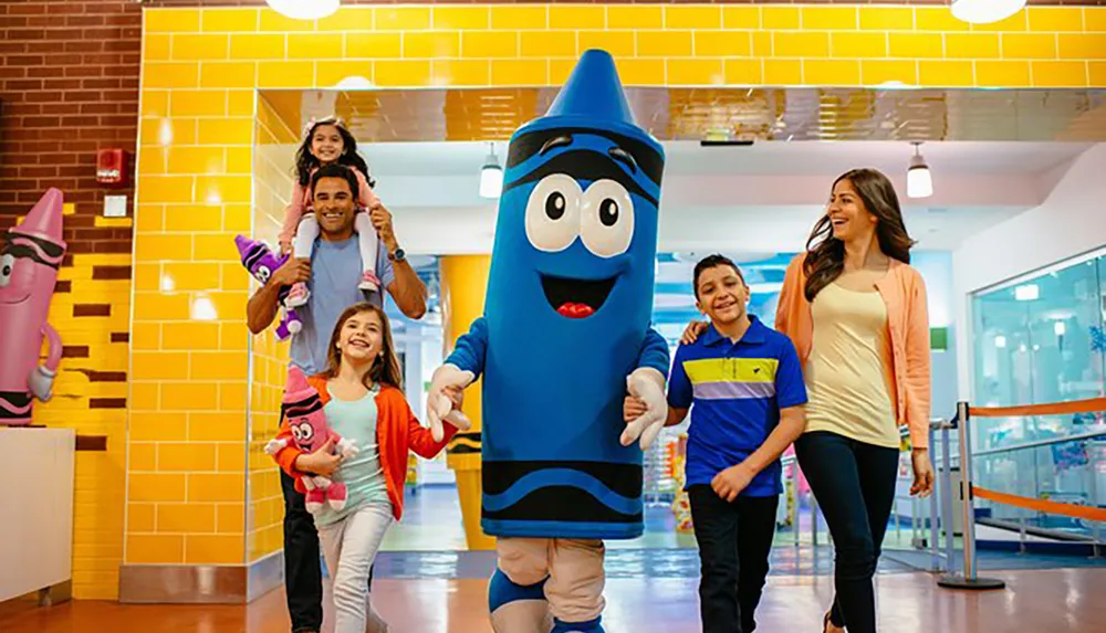 A family is enjoying a fun outing with two people in crayon costumes at a colorful playful location