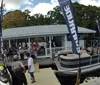 A group of people are enjoying a sunny day on a pontoon boat cruising on a calm body of water