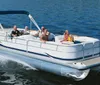 A group of people are enjoying a sunny day on a pontoon boat cruising on a calm body of water