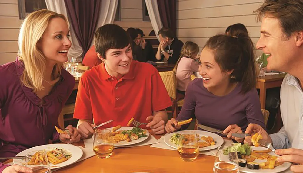 A family of four is enjoying a meal together at a restaurant engaged in a lively conversation