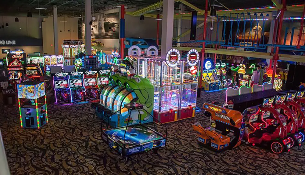 This image shows a vibrant and colorful arcade gaming floor with a variety of video games and attractions illuminated by bright neon lights