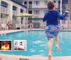 A child is joyfully jumping into a swimming pool at a hotel with amenities like free WiFi shuttle and breakfast advertised in the foreground