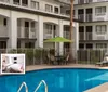 A child is joyfully jumping into a swimming pool at a hotel with amenities like free WiFi shuttle and breakfast advertised in the foreground