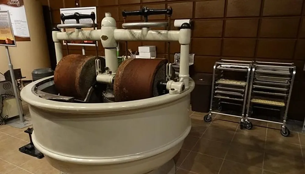 The image shows an antique dough mixer with large mixing drums in a vintage-style bakery setting