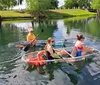 Three people are stand-up paddleboarding on a calm river with clear water and lush greenery in the background