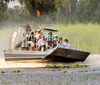 A group of people is enjoying an airboat tour through a scenic wetland area