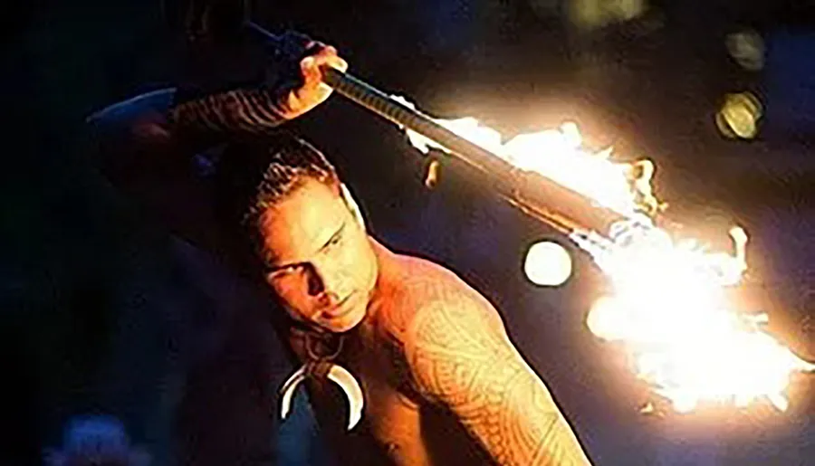A person is performing a fire breathing act in the dark.