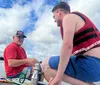 A person is captured mid-fall while waterskiing losing grip on the handle with water spraying around