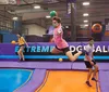 Children are joyfully jumping and playing on colorful trampolines in an indoor trampoline park