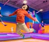 Children are joyfully jumping and playing on colorful trampolines in an indoor trampoline park