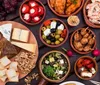 A group of people is smiling and posing for a photo at a long table in a cozy wine shop or bar