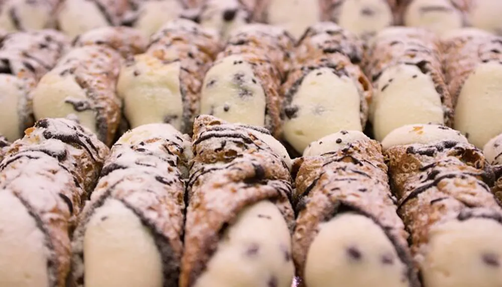 An arrangement of cannoli pastries filled with sweet cream and sprinkled with confectioners sugar