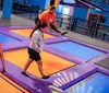 Children and adults are enjoying themselves while jumping on a colorful indoor trampoline park