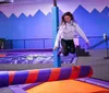 Children and adults are enjoying themselves while jumping on a colorful indoor trampoline park