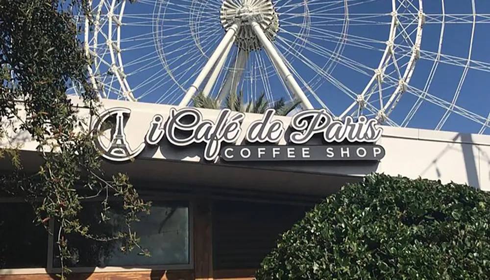 The image features the exterior sign of Caf de Paris Coffee Shop with a ferris wheel visible in the background