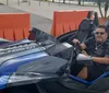 A person is seated in a parked Polaris Slingshot three-wheeled vehicle smiling and holding the steering wheel