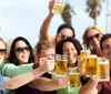 A group of cheerful people are toasting with glasses of beer outdoors