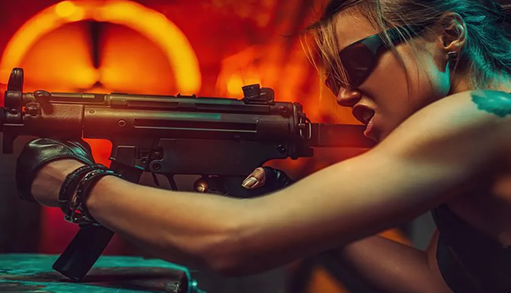 A person with sunglasses is aiming a submachine gun with a fiery backdrop adding intensity to the scene