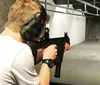 A woman is aiming a rifle at a shooting range under the supervision of an instructor