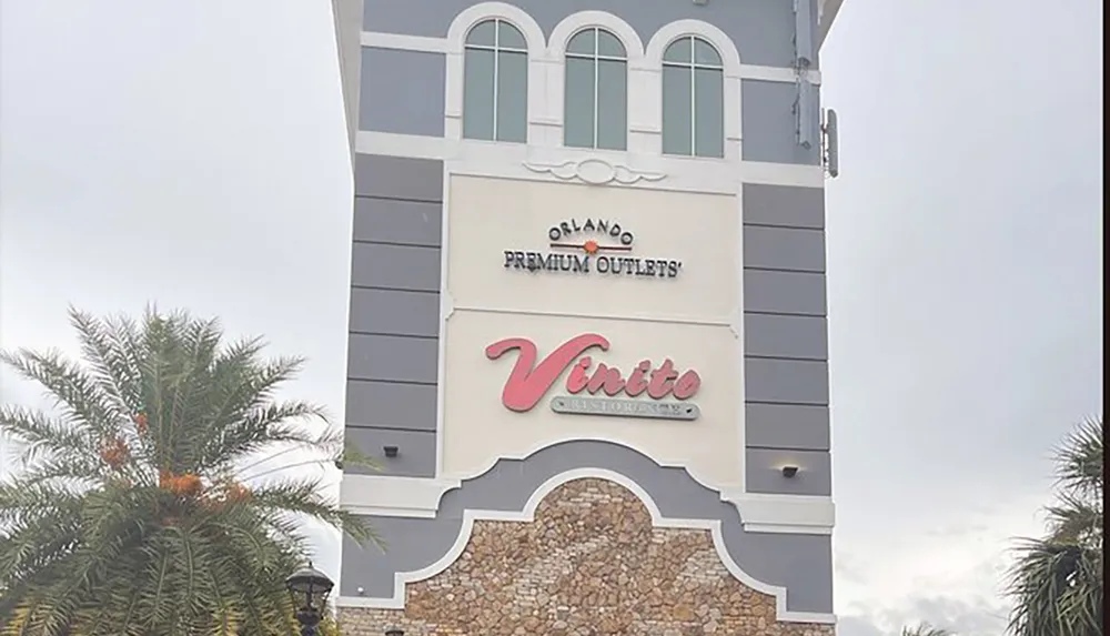 The image shows the exterior facade of a building with signs for Orlando Premium Outlets and Vinito Ristorante suggesting its a location that houses a dining establishment within a shopping outlet complex