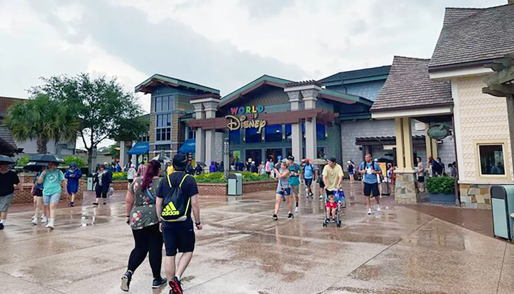 Visitors with umbrellas walk near the World of Disney store on a rainy day at an outdoor shopping area