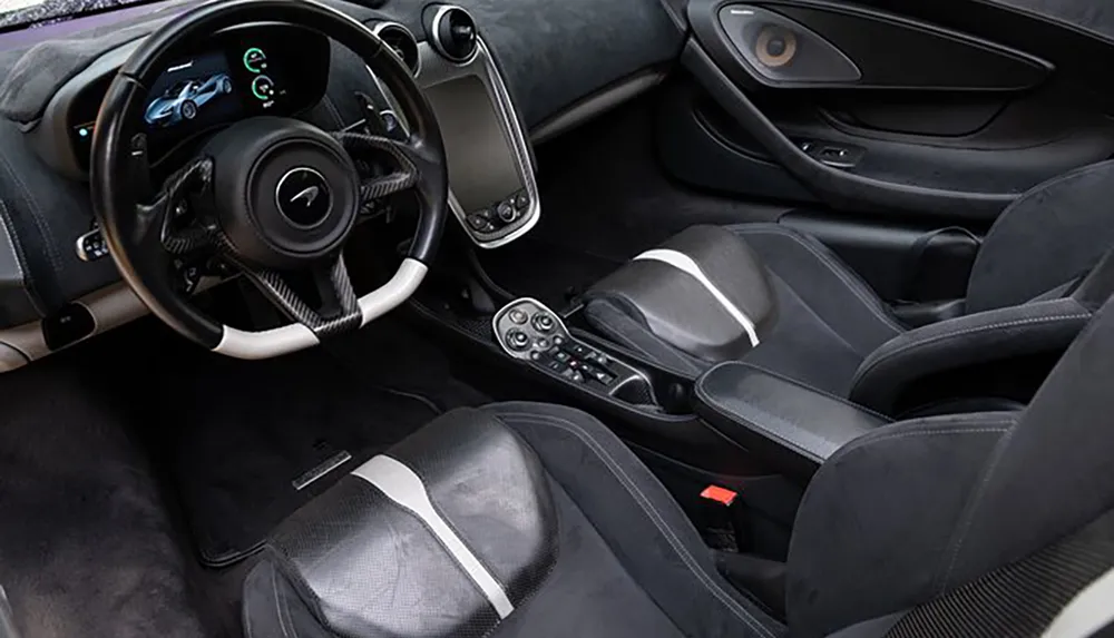 The image shows the modern and sporty interior of a car with a focus on the drivers seat steering wheel and center console