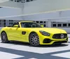 A bright yellow luxury convertible sports car is parked in an open-air parking structure