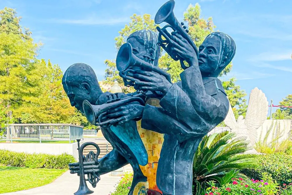 This image shows a vibrant sculpture of two figures playing trumpets in a garden setting