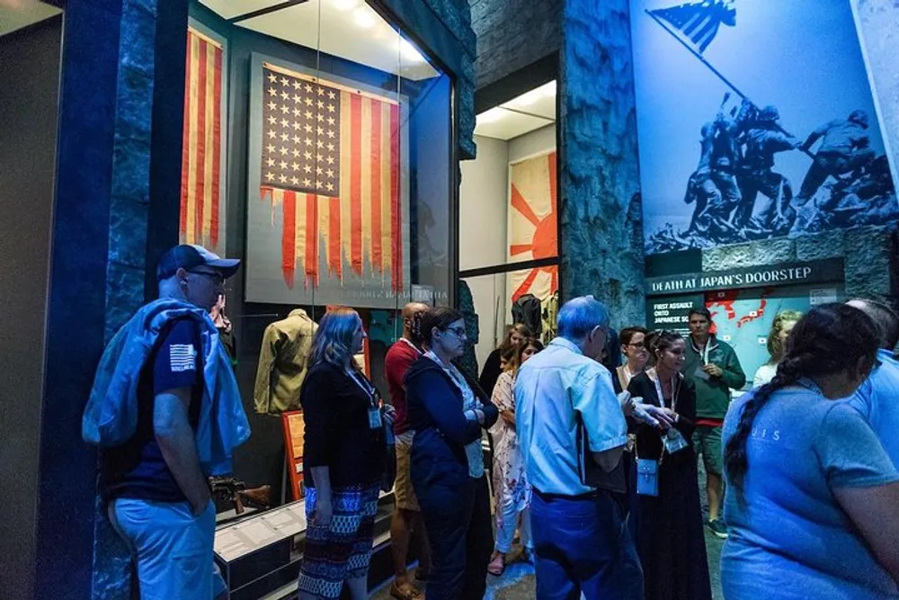 Visitors are viewing exhibits including two American flags and historical displays inside what appears to be a museum