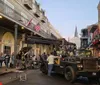A film crew is busy setting up equipment for a shoot on a street lined with classic buildings likely in the French Quarter of New Orleans