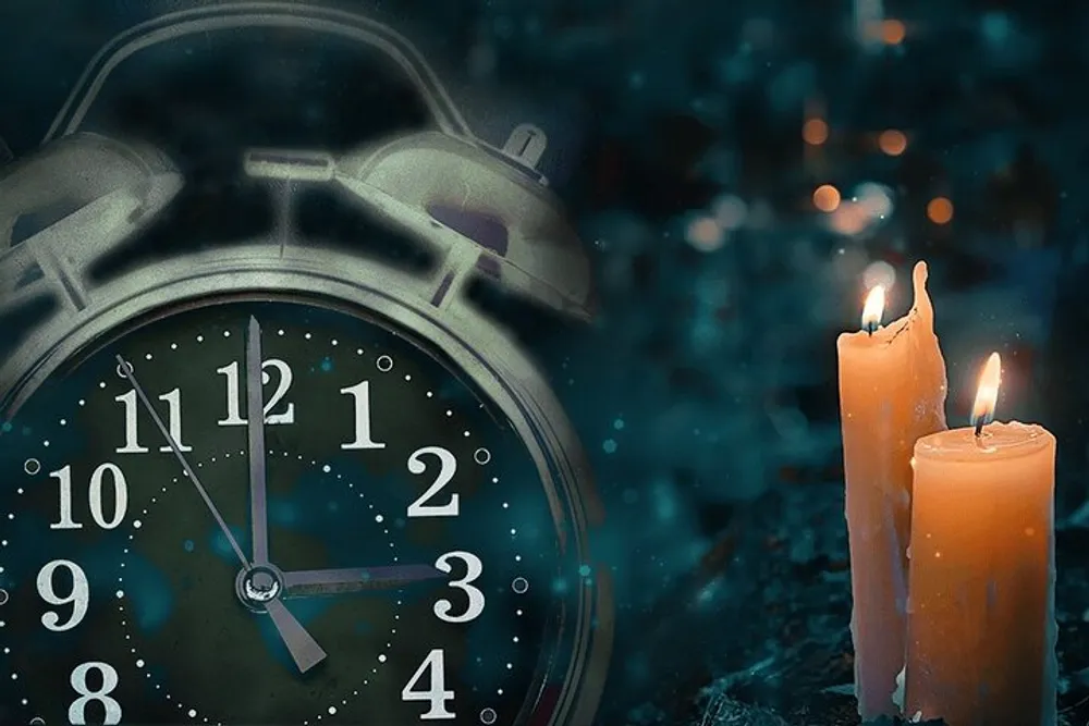 A vintage alarm clock showing approximately ten past eleven is placed next to two burning candles with a mystical blue-toned background