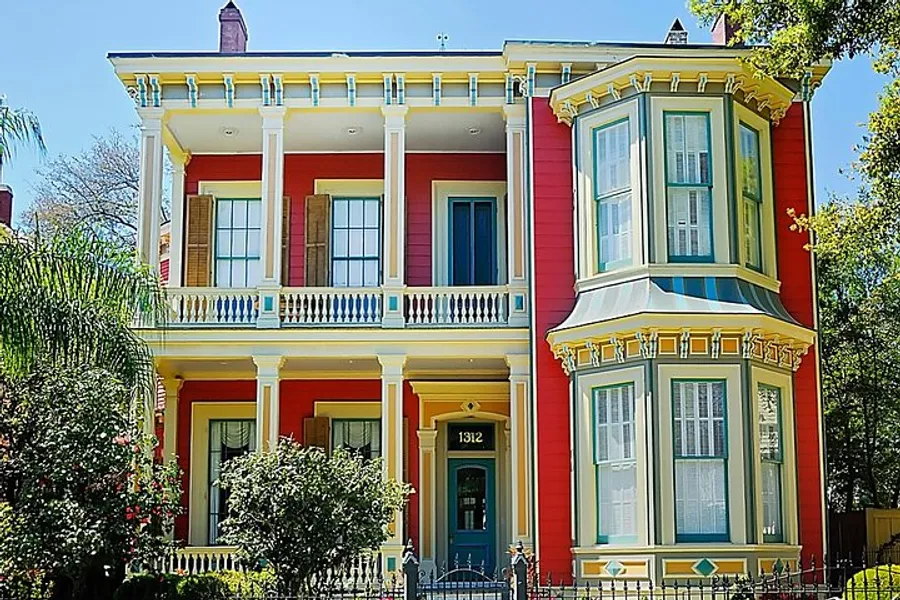 The image showcases a vibrant two-story Victorian house with a bay window and a colorful facade.