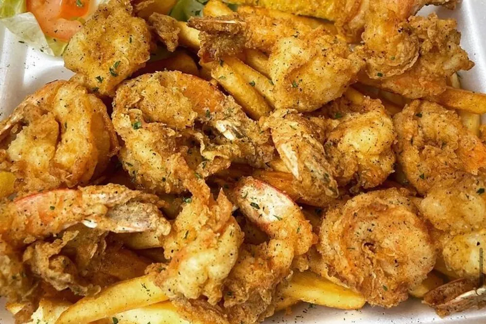 The image shows a serving of fried shrimp over French fries seasoned with herbs